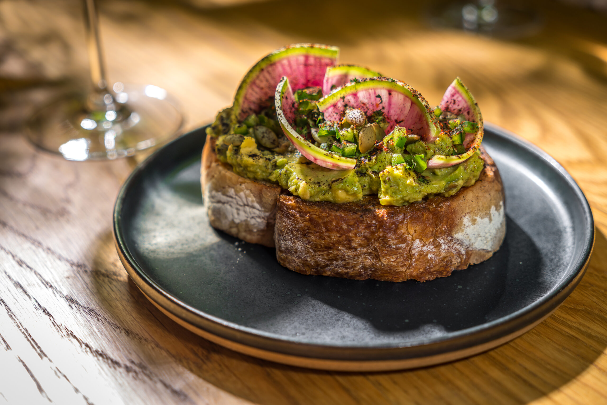 A thick slice of toast smothered in mashed avocado and topped with delicious garnishes.